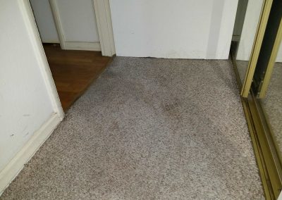 Carpeted hallway with mirrored closet doors.