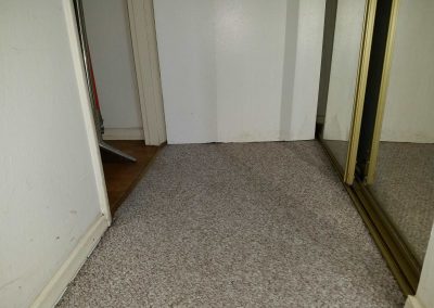Room corner with carpet and mirrored closet