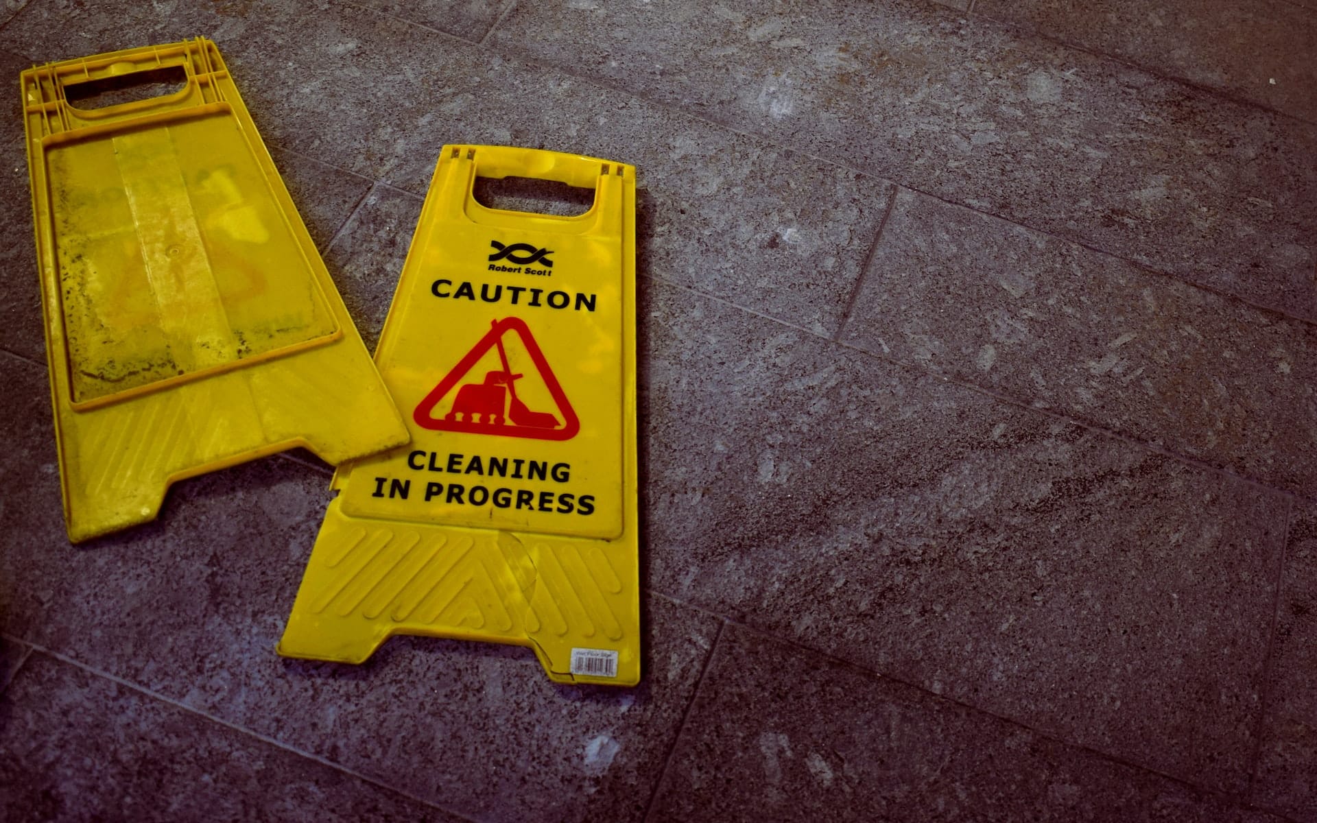 Yellow plastic signs that say "Cleaning in Process".