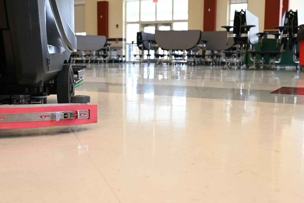 Floor cleaning machine in school cafeteria.