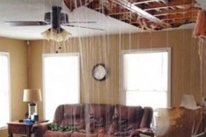 Living room with leaking ceiling and water damage.