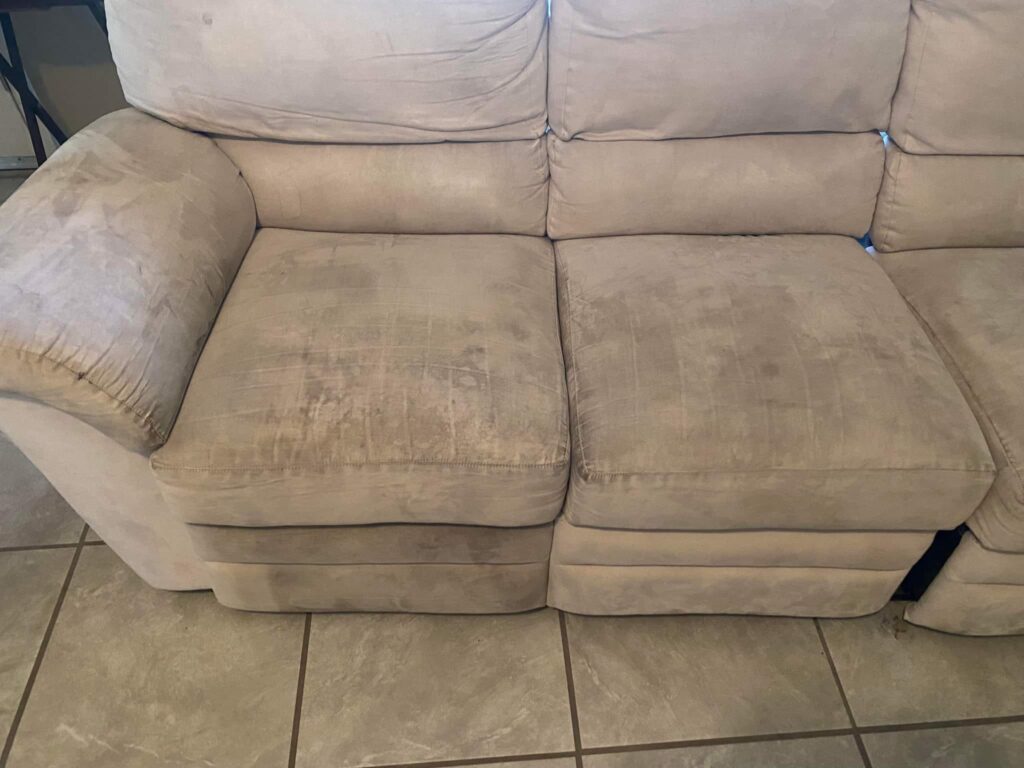Dirty, old 3-seats brown couch with stains.