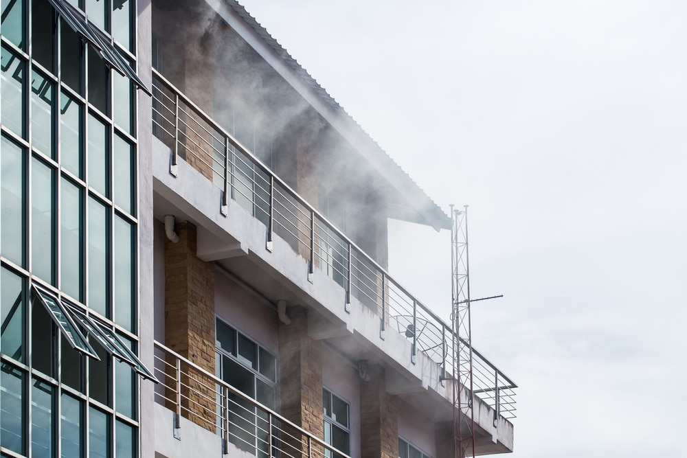 Smoke coming out from the front of a building due to a fire.