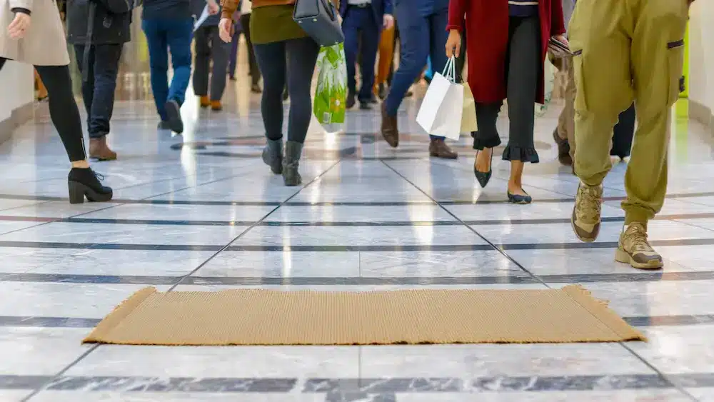 People walking inside a mall with shopping bags.